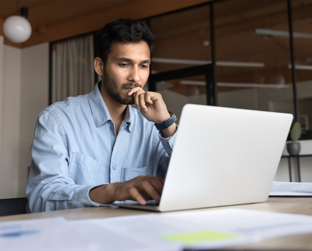 businessman staring at laptop screen deeply focused on his work