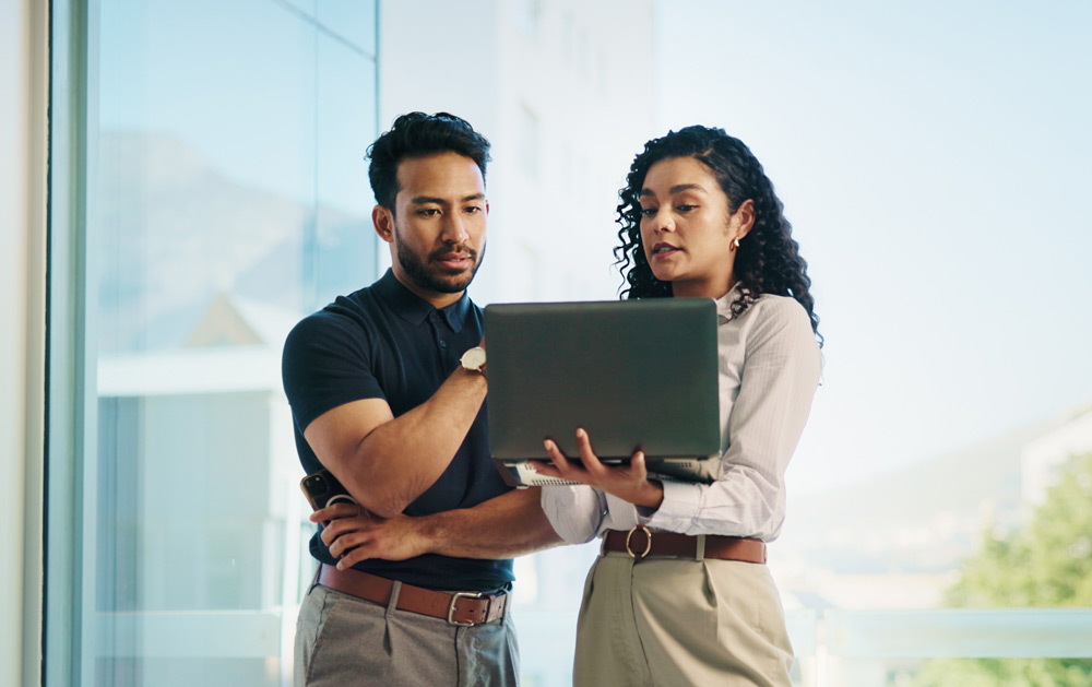 coworkers having a discussion with laptop in hand