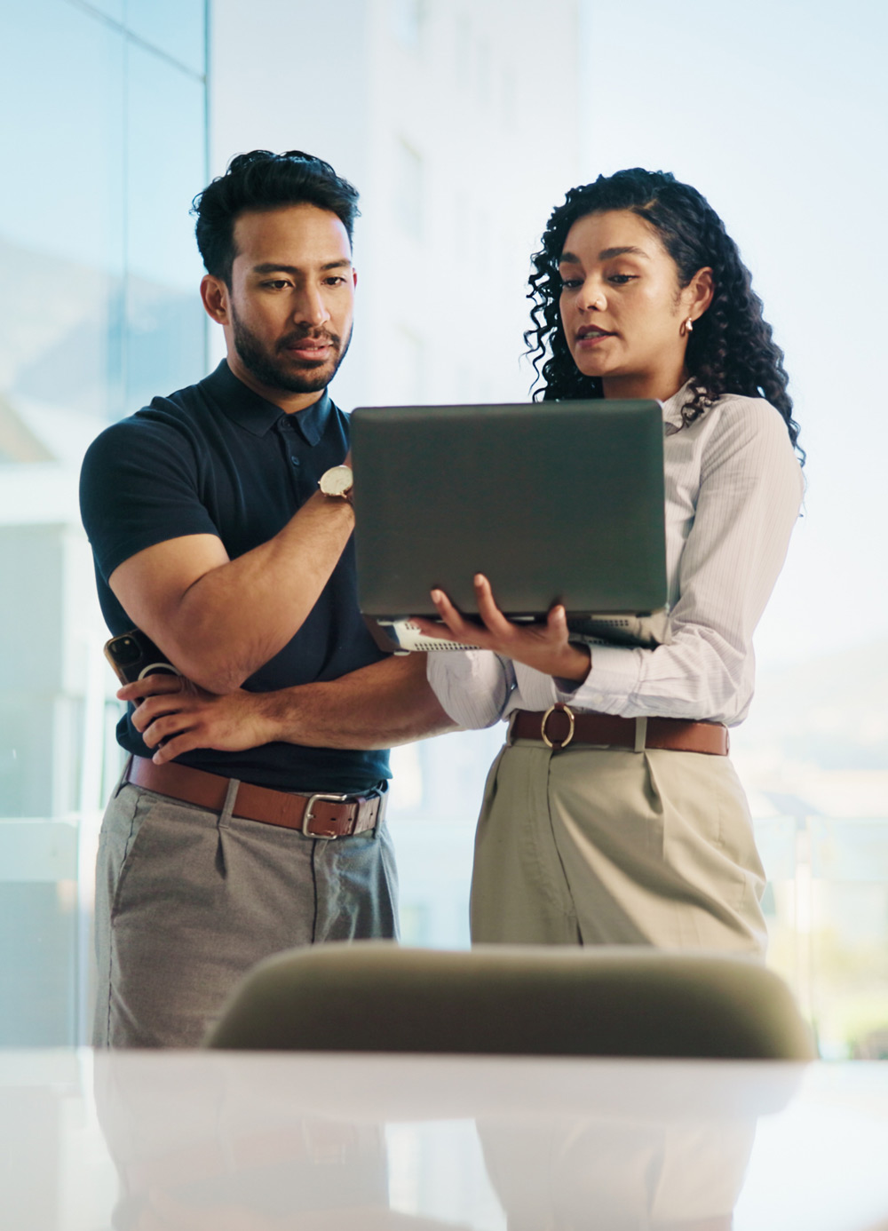 coworkers having a discussion with laptop in hand
