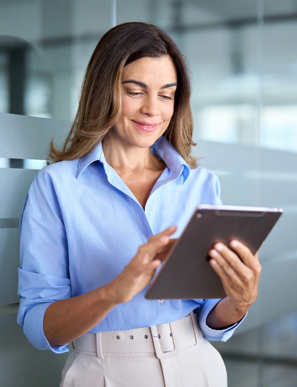 Smiling mature professional business woman using tablet