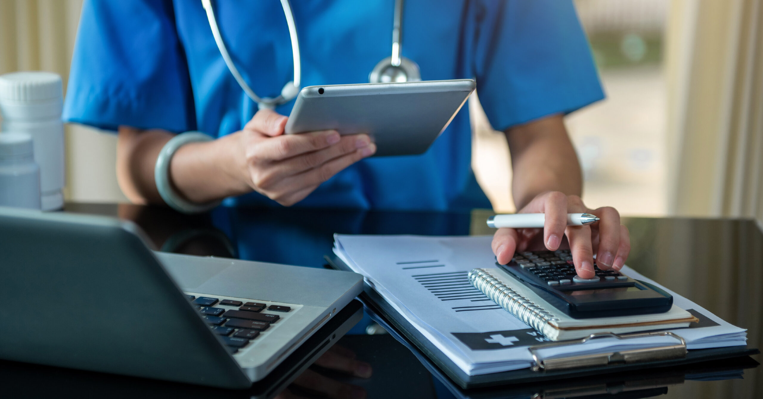 medical professional with calculator and prescription